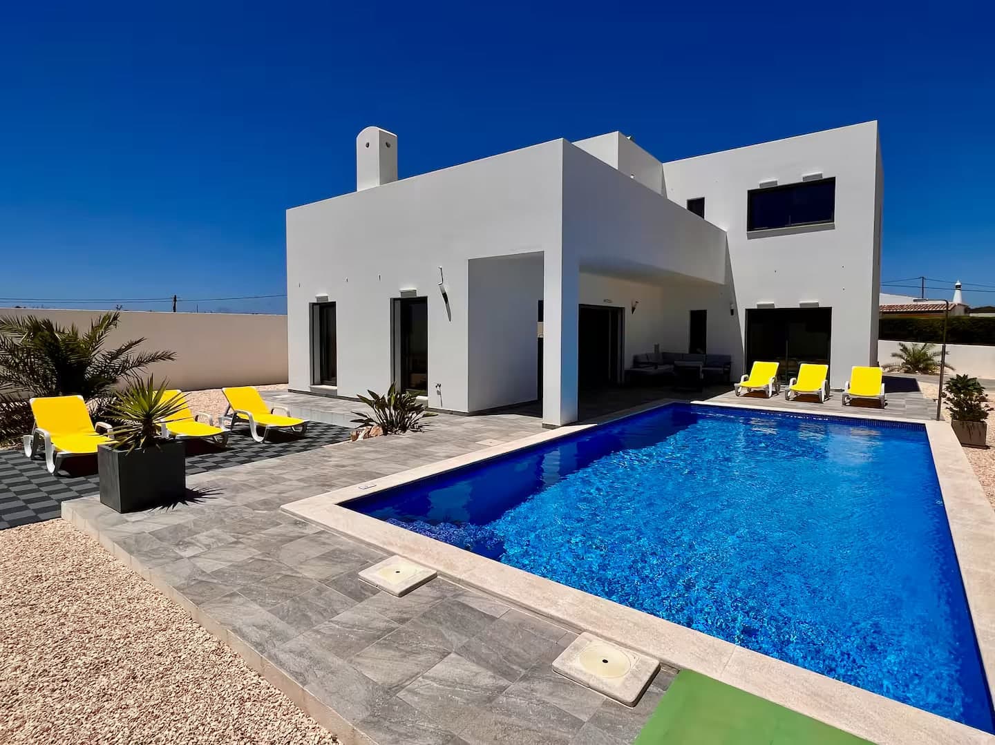 Poolterrasse mit Liegen in der Vormittagssonne