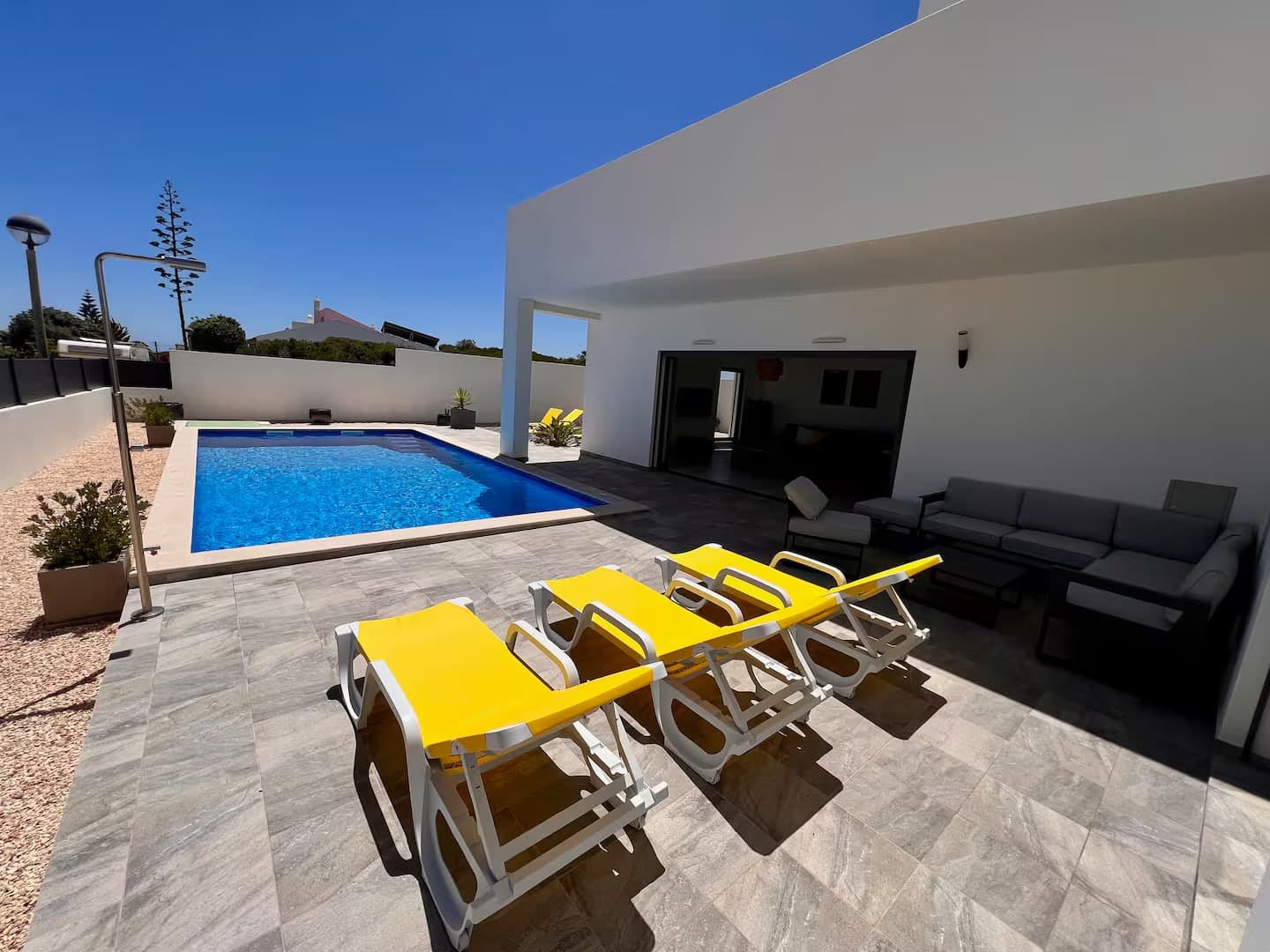 Überdachte Terrasse mit Außenmöbeln und Liegen am Pool
